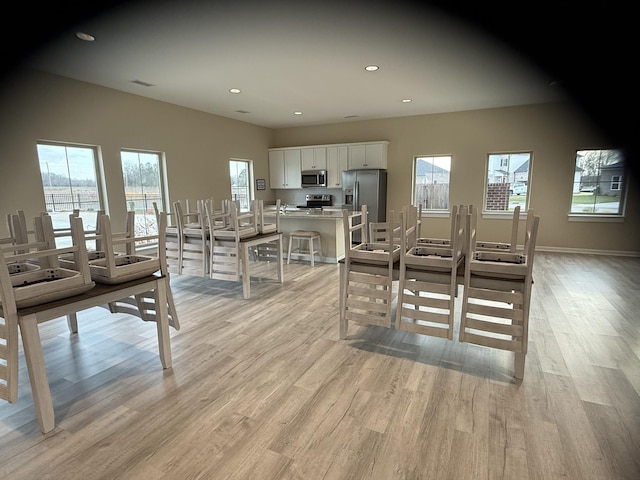 dining space featuring light wood finished floors, recessed lighting, and baseboards