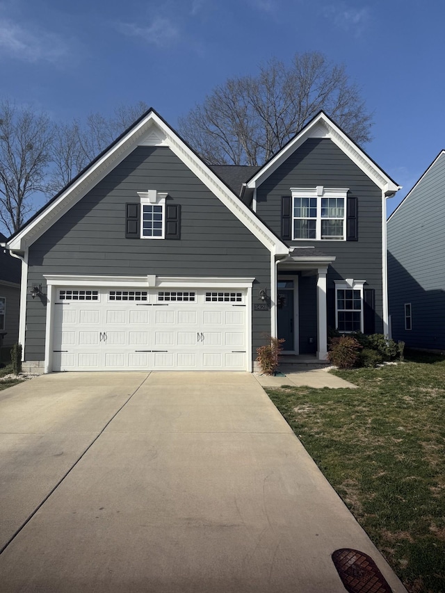 view of front facade featuring driveway, a front yard, and an attached garage
