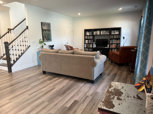 living area with wood finished floors, recessed lighting, stairs, and baseboards