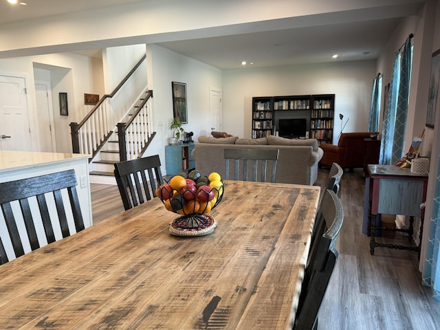 dining space featuring wood finished floors, stairs, and recessed lighting