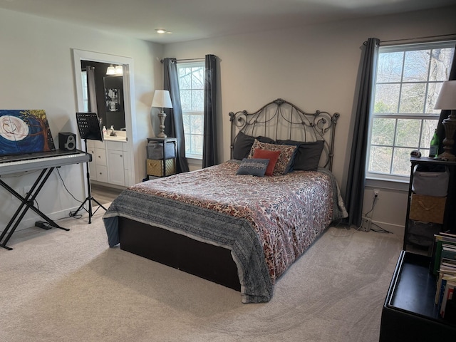 bedroom featuring light carpet, baseboards, and connected bathroom