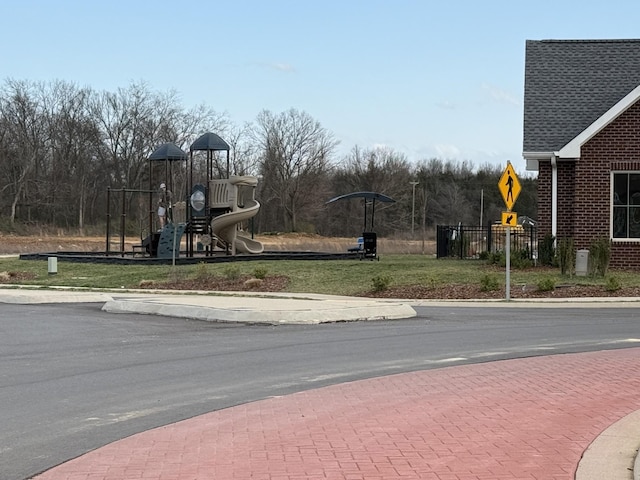 view of asphalt road with curbs, traffic signs, and sidewalks