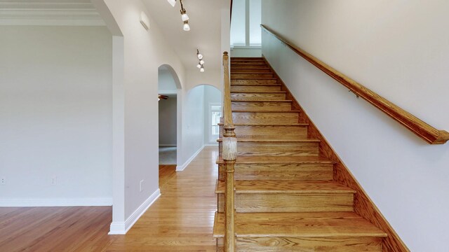4050 Oak Pointe Dr, Pleasant View, TN 37146 - stairway featuring arched walkways, wood finished floors, a towering ceiling, and baseboards