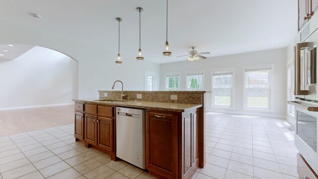 4050 Oak Pointe Dr, Pleasant View, TN 37146 - kitchen with stainless steel dishwasher, a sink, arched walkways, a ceiling fan, and light tile patterned floors