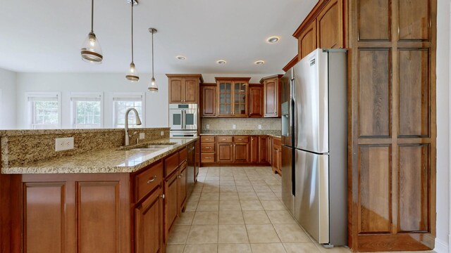 4050 Oak Pointe Dr, Pleasant View, TN 37146 - kitchen featuring stainless steel appliances, a sink, brown cabinetry, backsplash, and light stone countertops