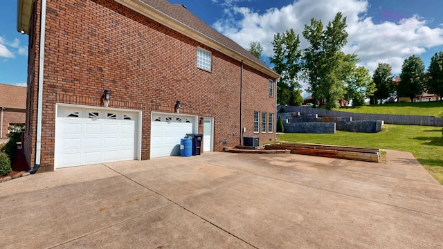 4050 Oak Pointe Dr, Pleasant View, TN 37146 - view of side of home featuring a yard, driveway, brick siding, central air condition unit, and a garage
