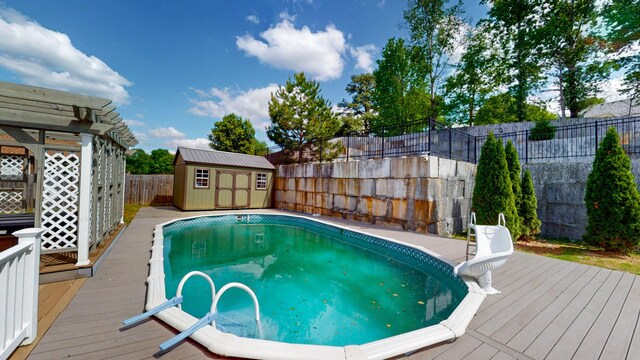 4050 Oak Pointe Dr, Pleasant View, TN 37146 - view of swimming pool featuring a deck, a storage shed, a fenced backyard, and an outbuilding