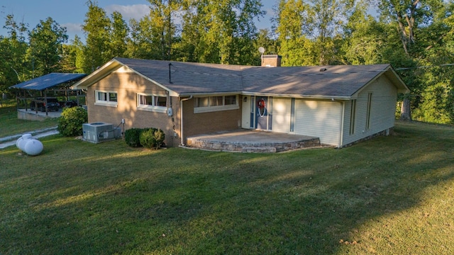 960 Knob Creek Rd, Lawrenceburg, TN 38464 - rear view of house with central AC, a chimney, a patio, a yard, and brick siding