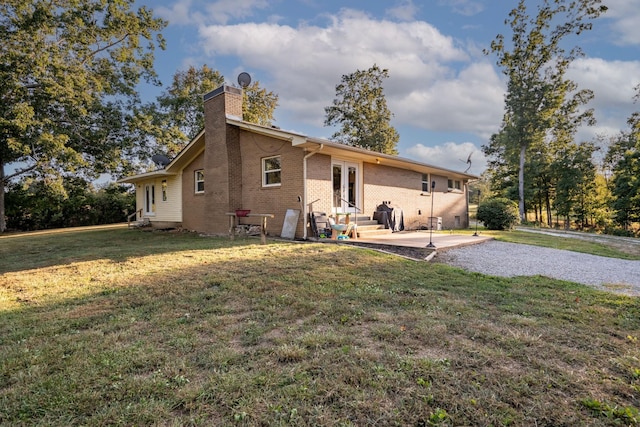 960 Knob Creek Rd, Lawrenceburg, TN 38464 - rear view of house featuring a chimney, entry steps, brick siding, a patio area, and a lawn
