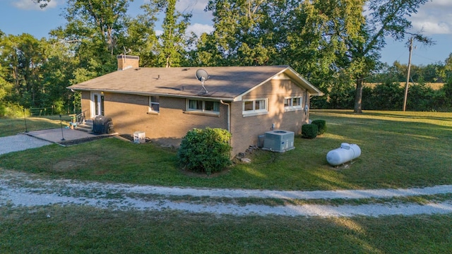 960 Knob Creek Rd, Lawrenceburg, TN 38464 - view of property exterior with cooling unit, a chimney, a yard, brick siding, and entry steps