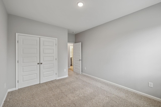 unfurnished bedroom featuring carpet floors, a closet, and baseboards