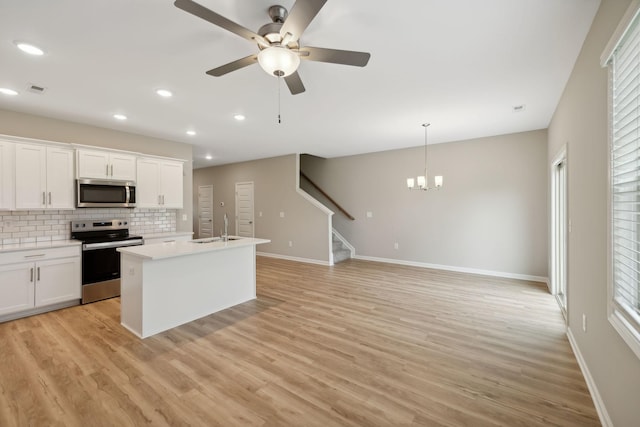 kitchen featuring appliances with stainless steel finishes, baseboards, a sink, backsplash, and recessed lighting