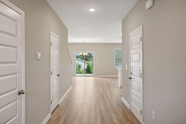 corridor with light wood-style flooring, baseboards, and recessed lighting