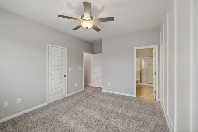 unfurnished bedroom featuring carpet, ensuite bathroom, baseboards, and ceiling fan