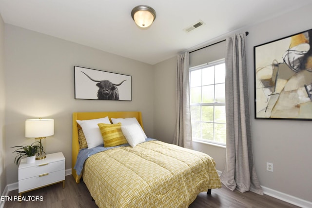bedroom featuring wood finished floors and baseboards