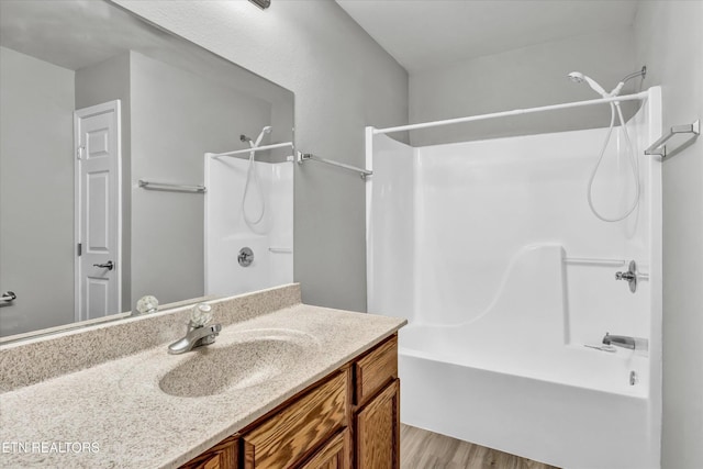 bathroom featuring bathing tub / shower combination, vanity, and wood finished floors