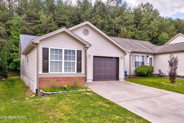view of front of house featuring a garage, concrete driveway, a front yard, and roof with shingles