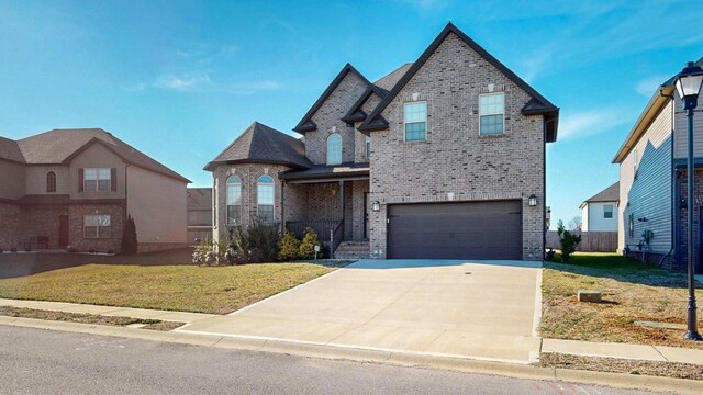 1408 Kingbird Dr, Clarksville, TN 37040 - french country home featuring brick siding, an attached garage, a front yard, and concrete driveway
