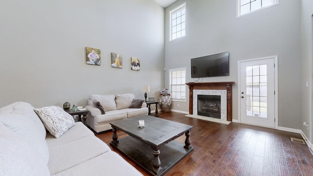 1408 Kingbird Dr, Clarksville, TN 37040 - living room featuring a towering ceiling, dark wood-style floors, a tile fireplace, and baseboards