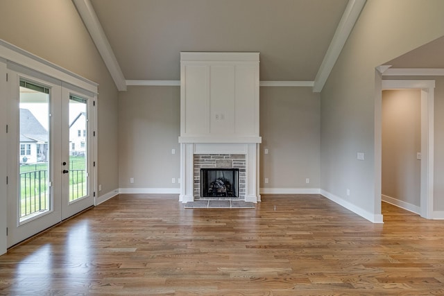 1022 Gadwall Ln, Spring Hill, TN 37174 - unfurnished living room featuring french doors, crown molding, light wood finished floors, a fireplace, and baseboards