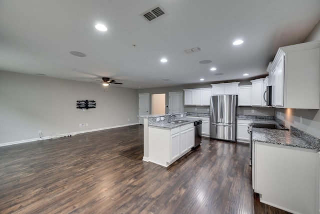 kitchen featuring stainless steel appliances, a ceiling fan, a center island, recessed lighting, and open floor plan