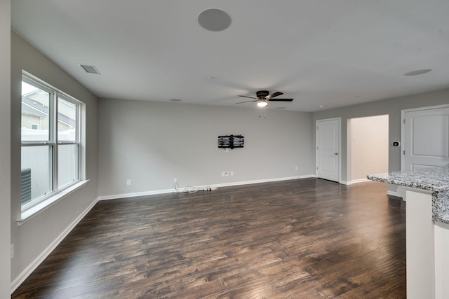 unfurnished living room with baseboards, dark wood-style flooring, and ceiling fan