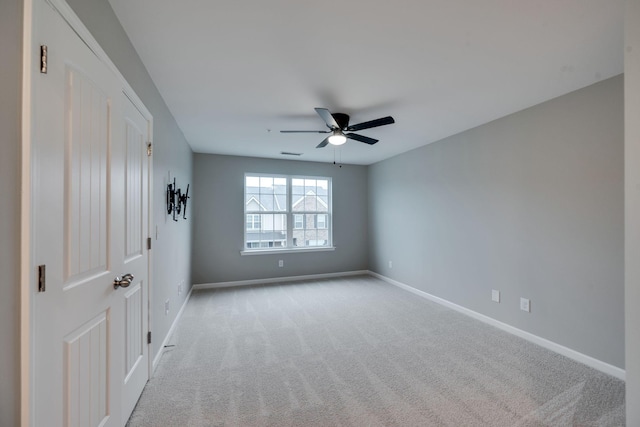 unfurnished bedroom featuring baseboards, light carpet, and a ceiling fan
