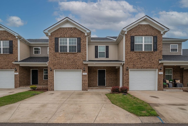 multi unit property with driveway, an attached garage, and brick siding