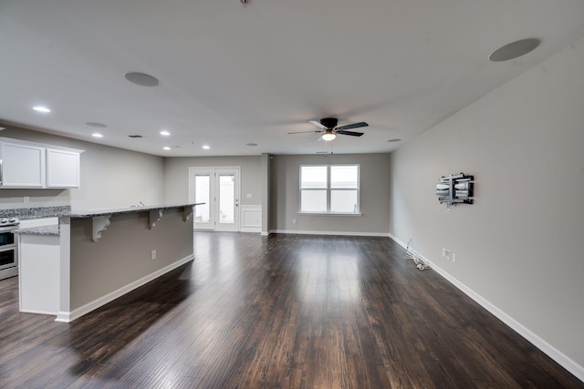 unfurnished living room featuring a ceiling fan, dark wood-style floors, recessed lighting, and baseboards