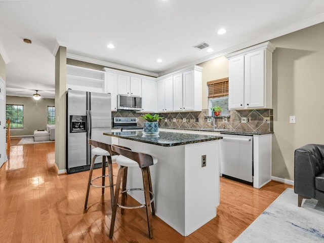 2050 Morrison Ave, Spring Hill, TN 37174 - kitchen with stainless steel appliances, a kitchen island, white cabinets, open shelves, and light wood finished floors