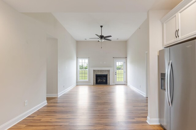 258 Jesse Dr, Pleasant View, TN 37146 - unfurnished living room featuring light wood-type flooring, a ceiling fan, baseboards, and a fireplace