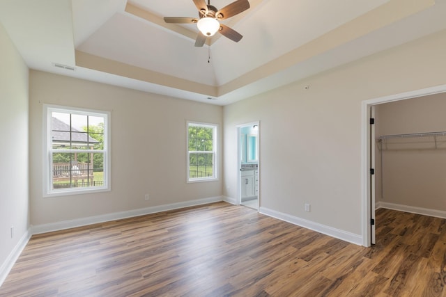 258 Jesse Dr, Pleasant View, TN 37146 - unfurnished bedroom featuring a tray ceiling, wood finished floors, a spacious closet, and baseboards