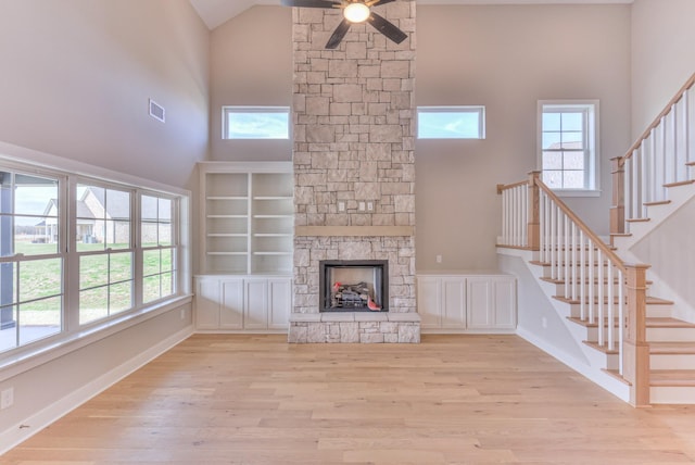 4109 Fargo Ct, Murfreesboro, TN 37127 - unfurnished living room with high vaulted ceiling, ceiling fan, wood finished floors, a stone fireplace, and stairs