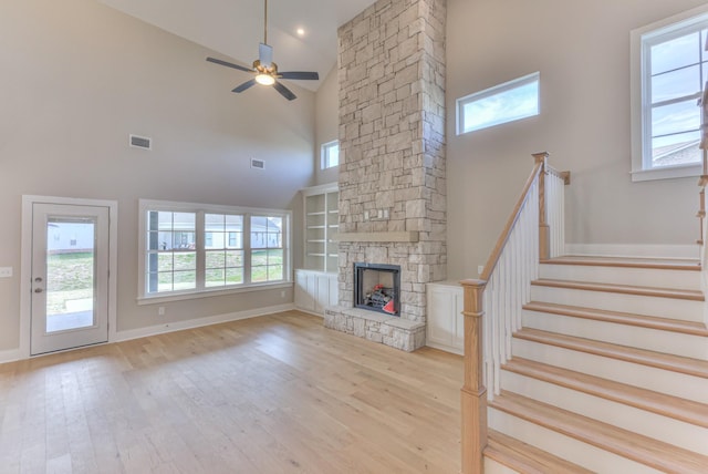 4109 Fargo Ct, Murfreesboro, TN 37127 - unfurnished living room with a towering ceiling, light wood finished floors, a stone fireplace, ceiling fan, and baseboards