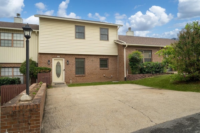 163 Heritage Trace Dr, Madison, TN 37115 - split level home with brick siding, a chimney, and a patio