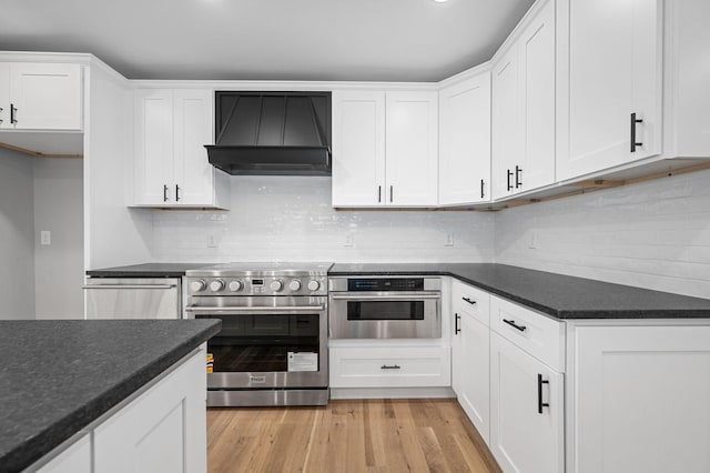 1311 Halifax Ct, Murfreesboro, TN 37130 - kitchen with custom exhaust hood, stainless steel appliances, dark countertops, white cabinetry, and tasteful backsplash