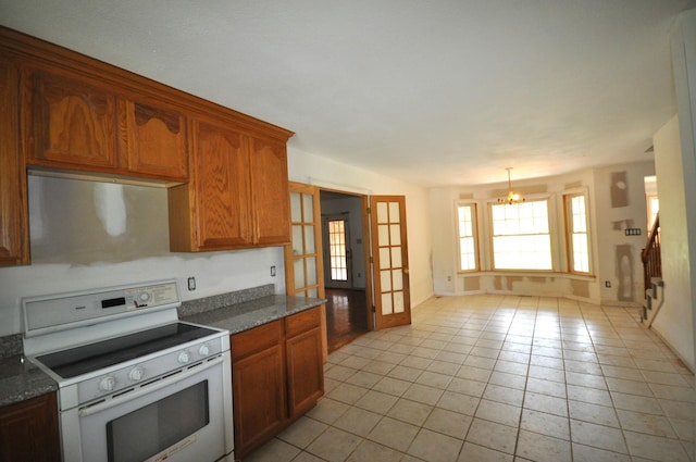 5620 Sango Rd, Clarksville, TN 37043 - kitchen with white electric range oven, a chandelier, light tile patterned flooring, baseboards, and brown cabinetry