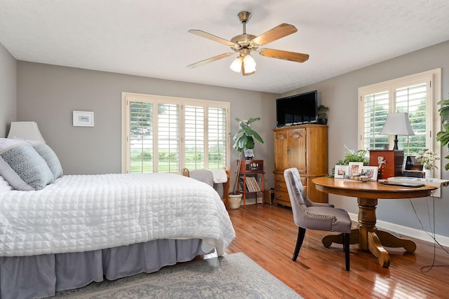bedroom with multiple windows and light wood-type flooring