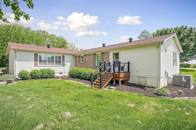 rear view of house featuring a lawn and crawl space