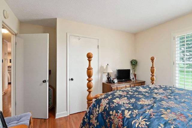 bedroom featuring wood finished floors and multiple windows