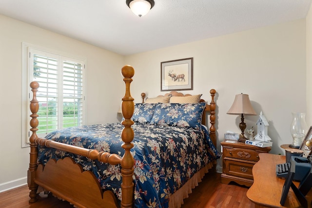 bedroom with wood finished floors and baseboards