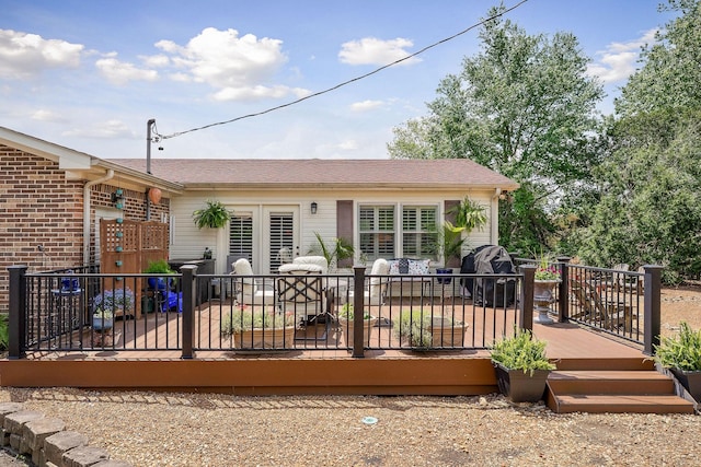 rear view of property featuring a wooden deck and a shingled roof