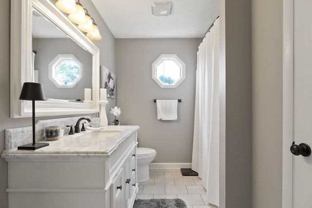 full bath with healthy amount of natural light, toilet, vanity, and baseboards