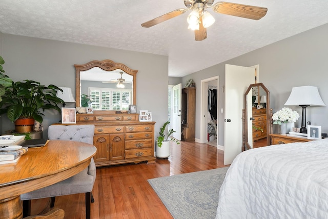 bedroom with wood finished floors, ceiling fan, and a textured ceiling