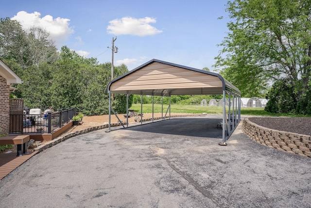 view of vehicle parking with asphalt driveway and a detached carport