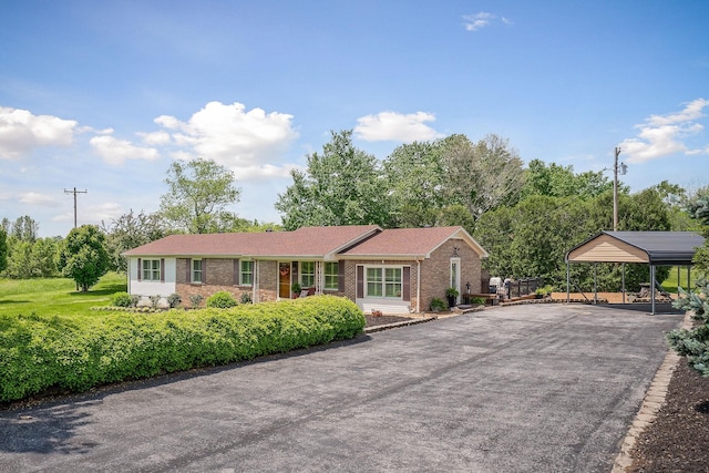 single story home with brick siding, a carport, and driveway