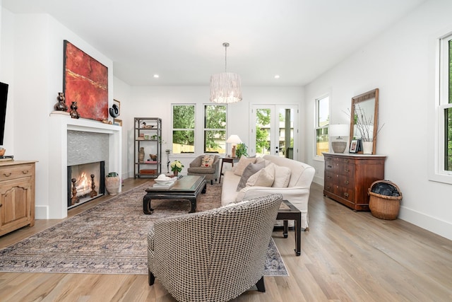 1411B Boscobel St, Nashville, TN 37206 - living room with light wood-type flooring, a chandelier, a warm lit fireplace, recessed lighting, and baseboards