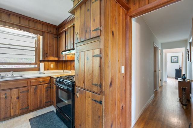 511 Catalina Dr, Nashville, TN 37217 - kitchen with black range with gas cooktop, a sink, under cabinet range hood, brown cabinetry, and light countertops