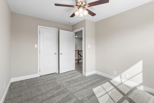 unfurnished bedroom with carpet floors, baseboards, and a ceiling fan