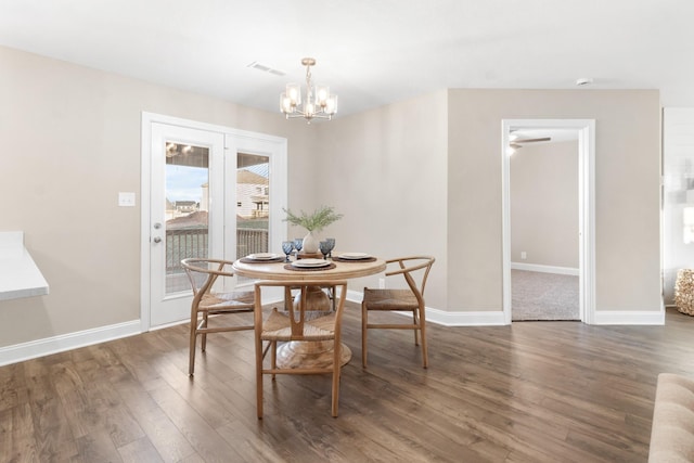 dining room with wood finished floors, a chandelier, and baseboards
